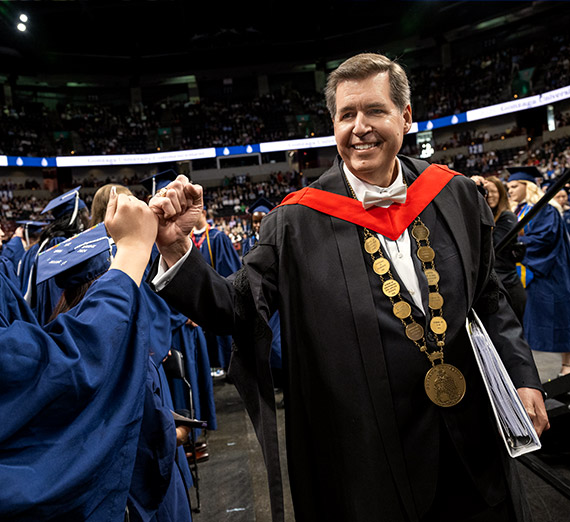 President McCulloh giving a speech with sparkling lights in the background.